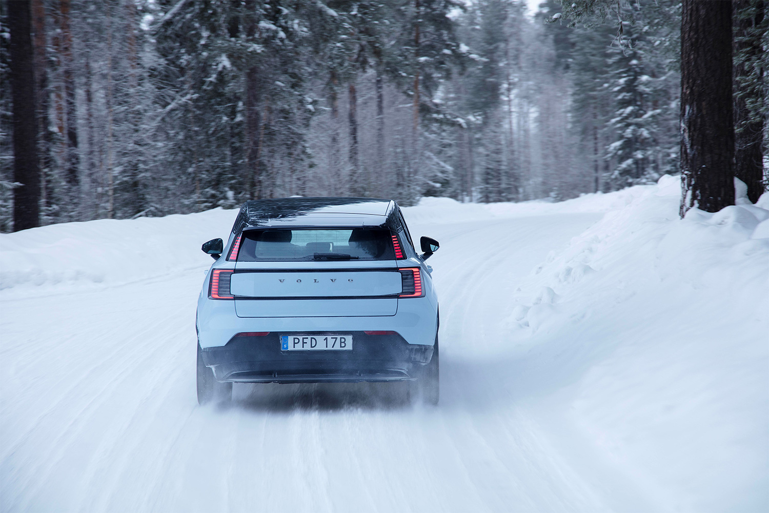 Volvo EX30 seen from behind as the EV drives on a snowy road