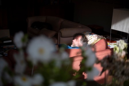 Man sleeping on sofa in his living room. We asked sleep experts about people who have sleep anxiety in a bed, but can sleep fine on a couch.