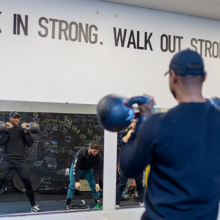 A man lifting kettlebells during a freestyle gym workout session.